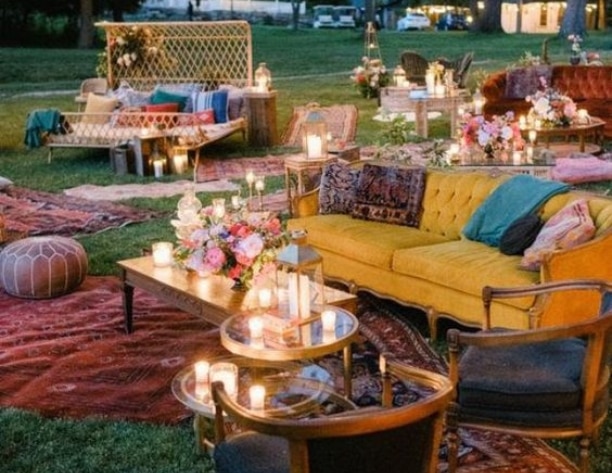 Colorful sofas and chairs organized outside with tables for event