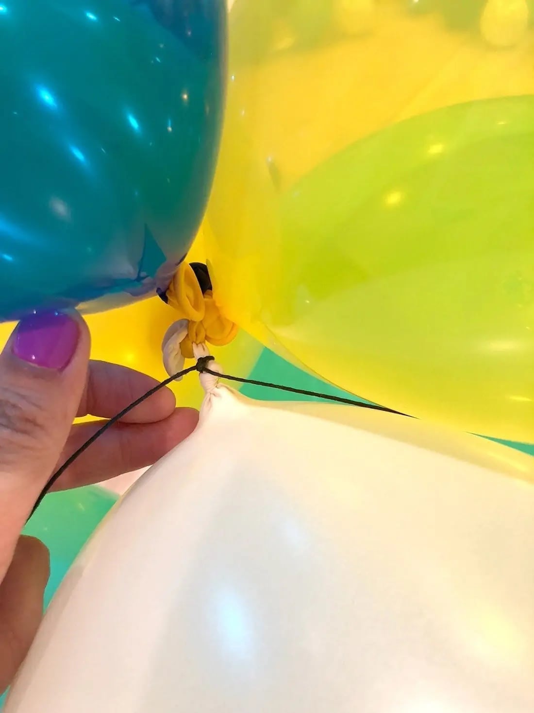 demonstrating how to tie balloons together