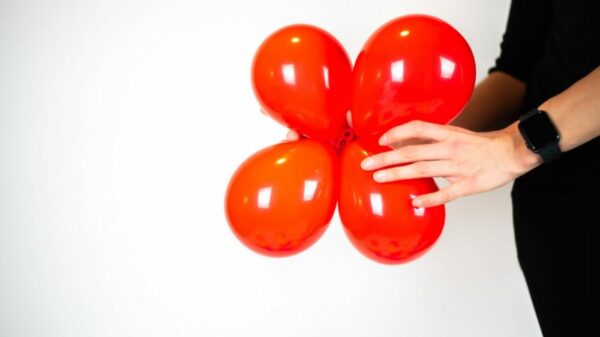 woman tying four balloons together